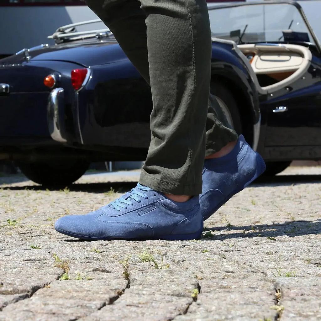 Paire de chaussures basses Sparco Imola en cuir suédé bleu jeans avec semelle bleue, portée