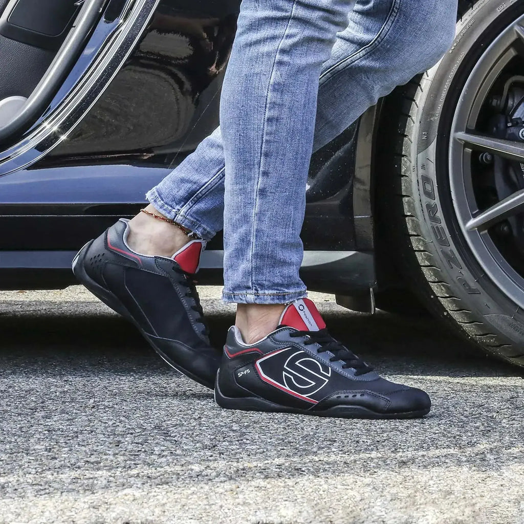 Paire de Sneakers Sparco SP-F5 noir et rouge, empiècement effet carbone, semelle noire qui remonte sur le talon, gros logo S blanc sur le côté, portée