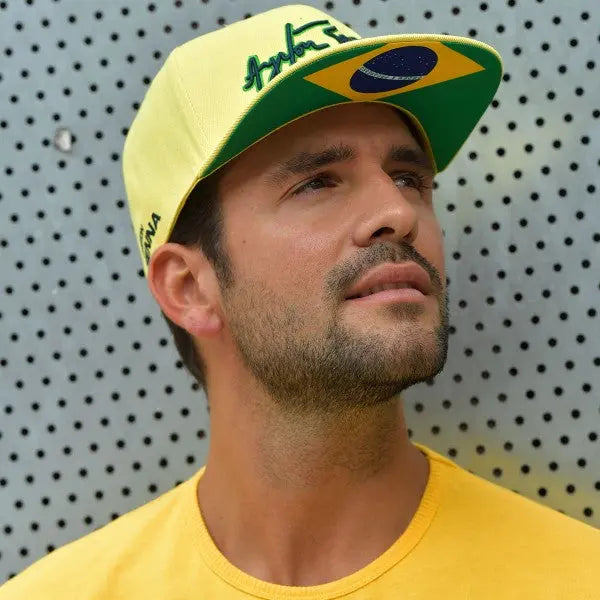 Casquette jaune Ayrton Senna avec sa signature bleue brodée devant, visière plate avec drapeau brésilien dessous, portée