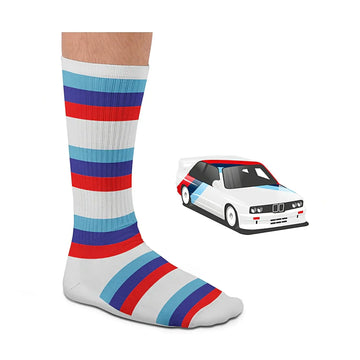 Chaussette de sport blanche Heel Tread portée, aux bandes rouges et bleues de la BMW E30, à côté de la voiture modélisée