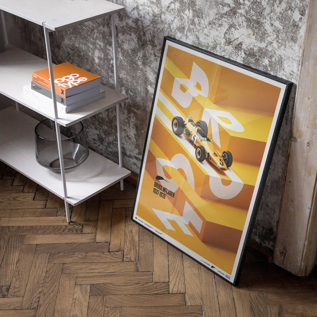 Affiche Automobilist jaune de la McLaren Papaya de Bruce McLaren modélisée en 3D sur un escalier avec le lettrage Bruce en blanc dans un cadre 