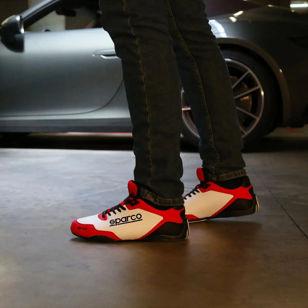 Paire de Sneakers Sparco SP-F12 blanc rouge et noir, lacets et semelle noirs qui remonte sur le talon, gros logo Sparco noir sur le côté, portée