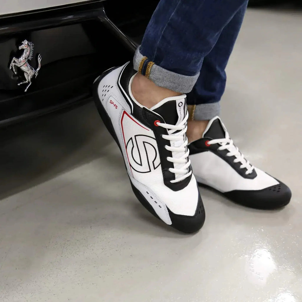 Paire de Sneakers Sparco SP-F5 blanc noir, empiècement effet carbone, semelle noire qui remonte sur le talon, gros logo S noir sur le côté, portée